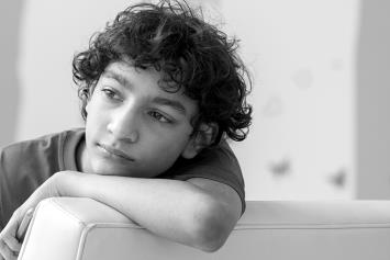 Reflective Teen Boy Resting Arm on Chair