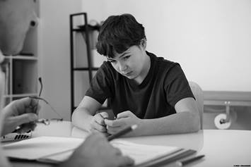 Child sitting at desk with teacher