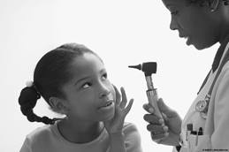 Physician checking on child's ear before ear tube removal.