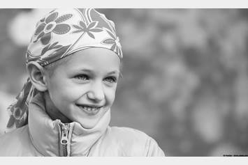 Child in winter coat wearing a scarf over her head