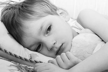 Child laying in bed.