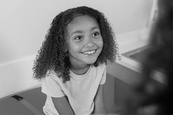 Little girl smiling up at someone
