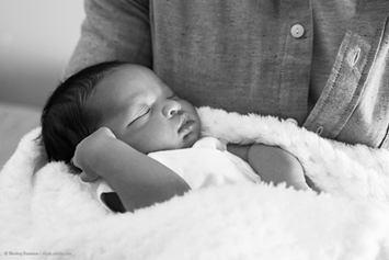 baby sleeping and being held in a blanket